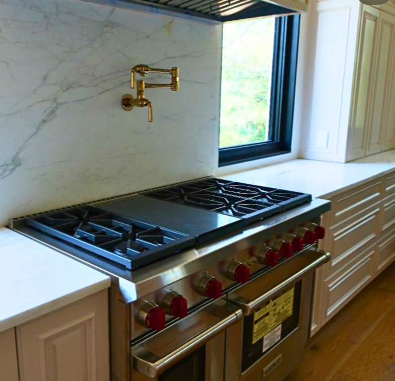 Brass pot filler and marble detail in the remodeled kitchen