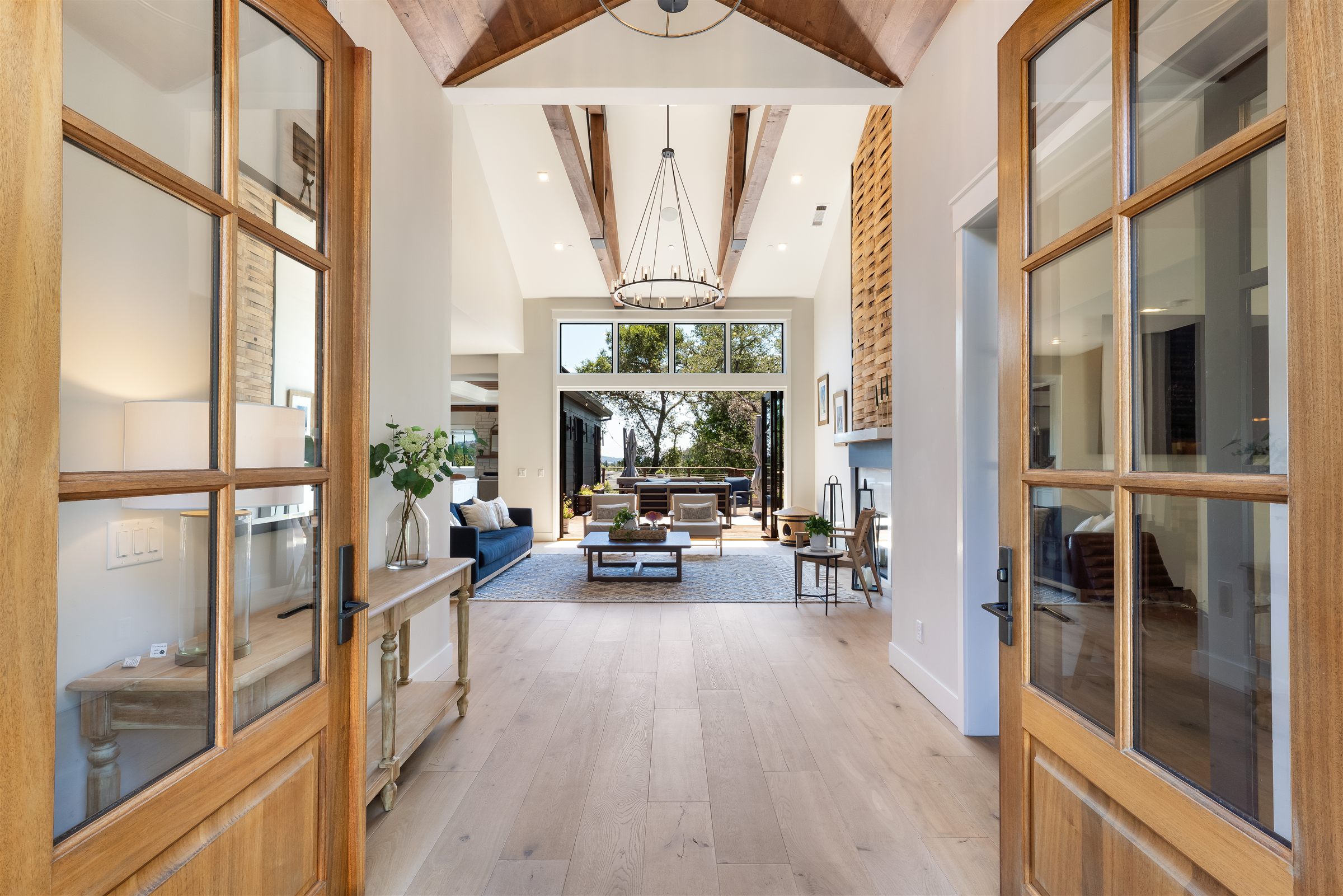 Vaulted great room with reclaimed barnwood wall and iron chandelier